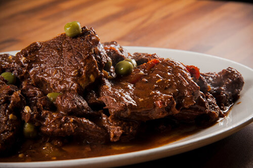 Horse meat covered with a gravy along with peas and carrots