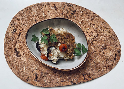 The final plating of the tiella with all the components neatly spread across the plate garnished with parsley