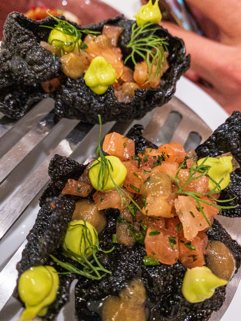 Squid Ink Cracker with cured salmon, capers and a raisin puree