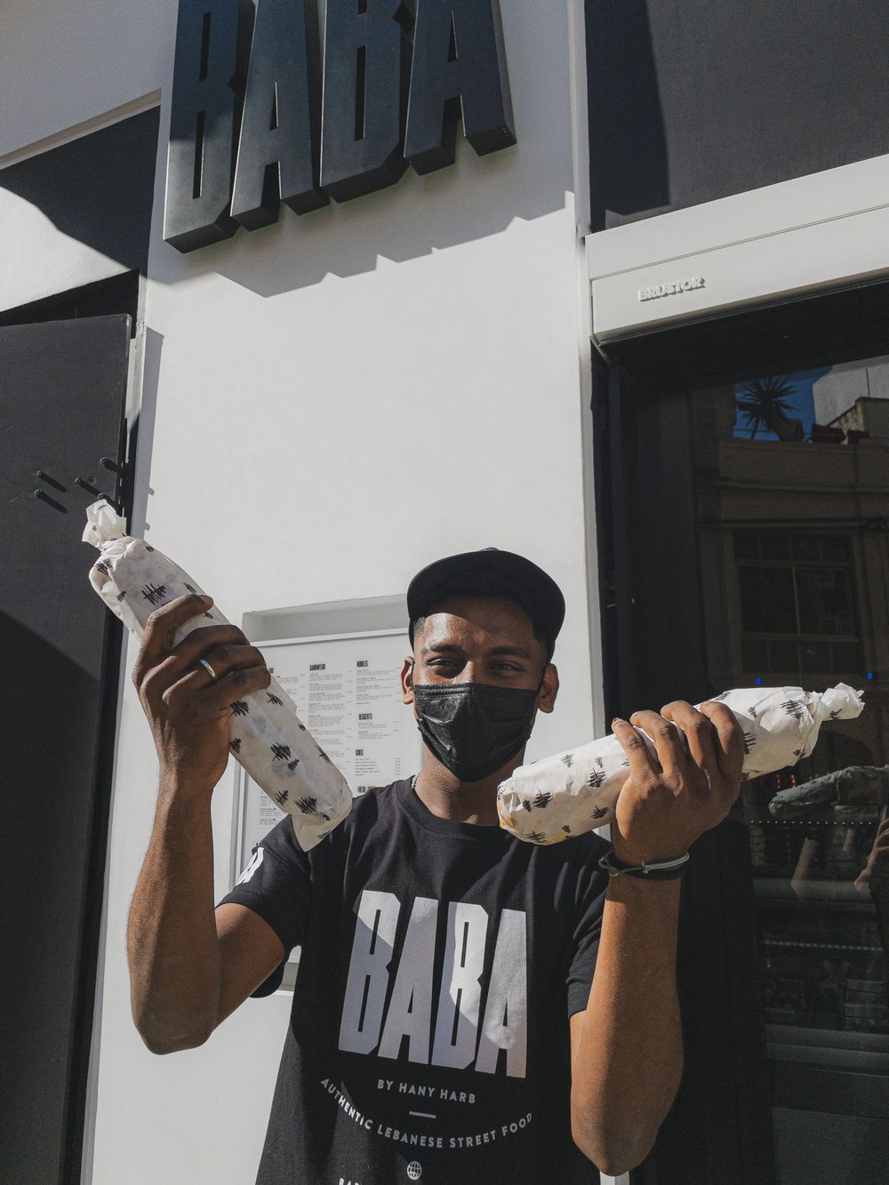 Happy employee outside BABA showing off their packaging