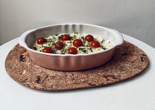 The first layer of the tiella assorted with rice, parsley and tomatoes