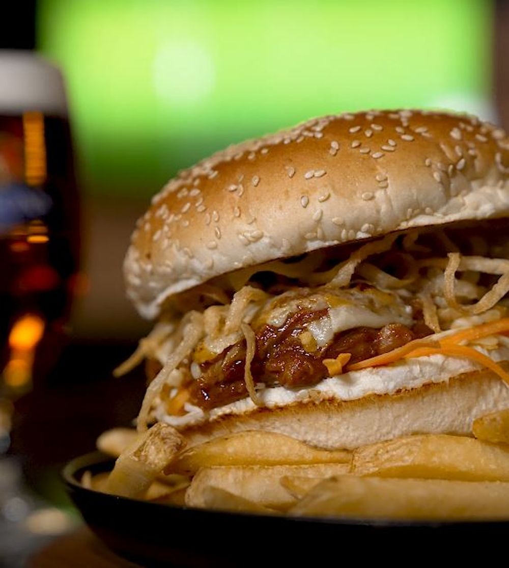 Porky Burger:  Slow-cooked pulled pork, homemade BBQ sauce (with Blue Label), smoked cheddar cheese, pickled slaw and crispy onions, all served in Brioche bun!