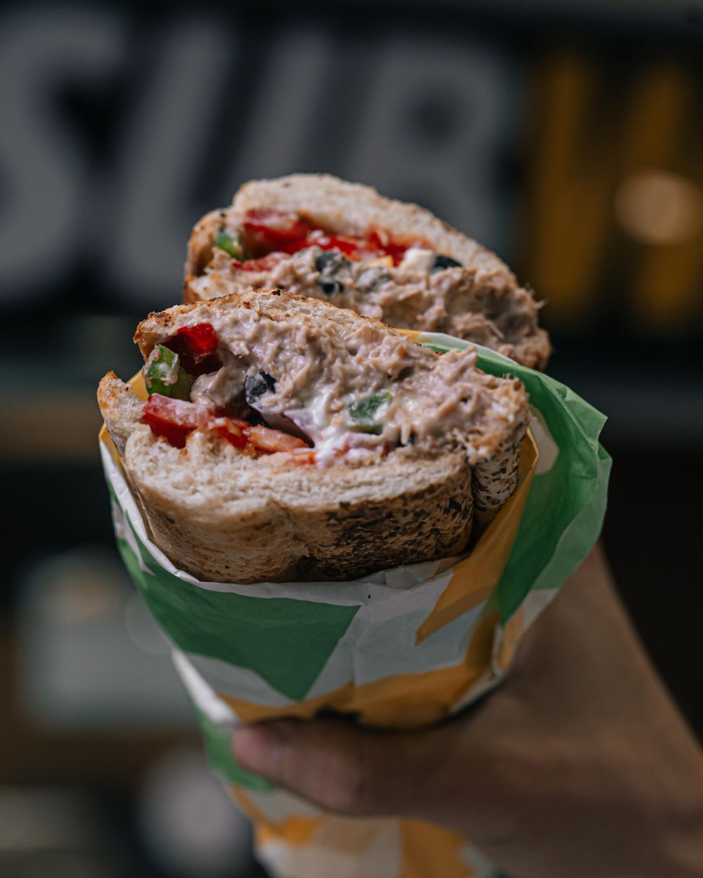 A subway sandwich with tuna and mayo plus mixed fresh vegetables.