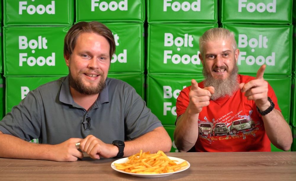 Pavel and Mark from Bolt Food with Bolt Take away carries behind them